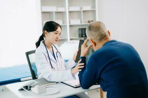 sérieux Asie femelle médecin en utilisant presse-papiers est livrer génial nouvelles parler discuter résultats ou symptômes avec femelle patient dans clinique ou hôpital photo