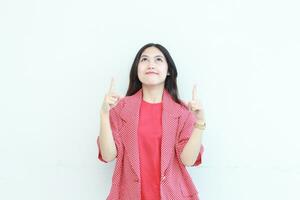 portrait de magnifique asiatique femme portant rouge tenue montrer du doigt en haut pour copie espace avec souriant geste photo