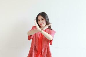 portrait de magnifique asiatique femme portant rouge tenue avec rejet ou désapprobation geste photo