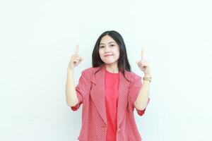 portrait de magnifique asiatique femme portant rouge tenue montrer du doigt en haut pour copie espace photo