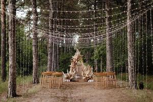 Zone de cérémonie de mariage avec des fleurs séchées dans un pré dans une forêt de pins photo