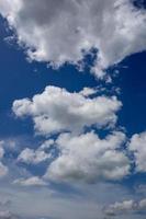 nuages blancs duveteux dans le fond de ciel bleu photo