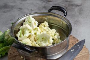 le chou-fleur frais se prépare pour la cuisson sur une table grise photo