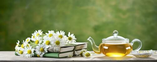 camomille fleurs, livres, une verre théière, et une tasse de à base de plantes thé sur une table fermer. génératif ai photo