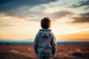 une enfant regarder à le horizon isolé sur une crépuscule pente Contexte photo