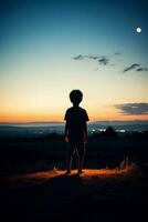 une enfant regarder à le horizon isolé sur une crépuscule pente Contexte photo