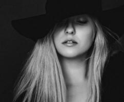 magnifique blond femme portant une chapeau, artistique film portrait dans noir et blanc pour mode campagne et beauté marque photo