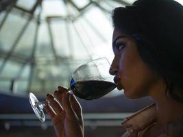 portrait d'une jolie fille avec de belles lèvres qui boit du vin rouge dans un verre photo