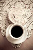 blanc tasse de noir café et une sucré de beurre biscuit sur le table photo