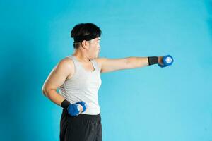 image de asiatique homme exercice sur bleu Contexte photo
