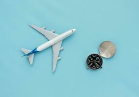 une avion miniature et une boussole isolé sur bleu arrière-plan, après certains modifications. photo
