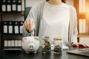 femme main en portant pièce de monnaie avec porc porcin banque. économie et financier comptes concept photo