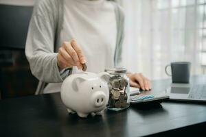 femme main en portant pièce de monnaie avec porc porcin banque. économie et financier comptes concept photo