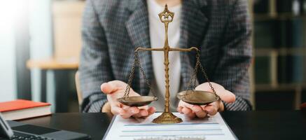 avocat masculin au bureau avec échelle en laiton sur table en bois. concept de justice et de droit à la lumière du matin photo