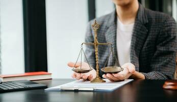 avocat masculin au bureau avec échelle en laiton sur table en bois. concept de justice et de droit à la lumière du matin photo