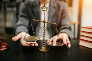 avocat masculin au bureau avec échelle en laiton sur table en bois. concept de justice et de droit à la lumière du matin photo