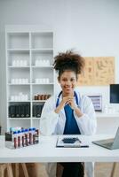 magnifique médecin médecin asseoir sur table dans Bureau hôpital. attrayant thérapeute femelle praticien pharmacien sourire et utilisation tablette et portable dans hôpital.après Succès travail de traitement photo