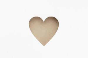 en forme de coeur en carton découpé isolé sur fond de papier blanc. notion d'amour photo