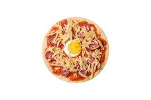 pizza maison avec saucisses, tomates, fromage, épices et herbes sur une planche à découper en bois photo