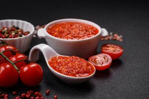 délicieux chaud épicé rouge sauce avec sel et épices dans une céramique bol photo