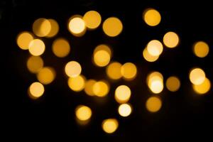 Jaune et marron défocalisé lumières sur noir Contexte. flou bokeh, recouvrir. Noël, Nouveau année, vacances photo