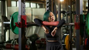 très magnifique adolescent fille repos et avoir motivée entre ensembles de haltère squats dans salle de sport. photo