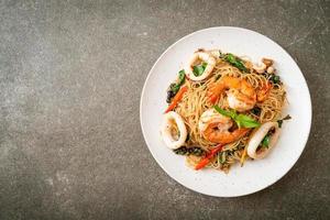 nouilles chinoises sautées au basilic, piment, crevettes et calamars - style cuisine asiatique