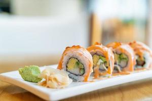 rouleau de saumon sushi avec sauce sur le dessus - style de cuisine japonaise photo