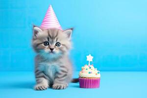 mignonne chaton avec anniversaire petit gâteau et fête chapeau sur bleu arrière-plan, mignonne chaton avec anniversaire chapeau et petit gâteau sur bleu arrière-plan, ai généré photo