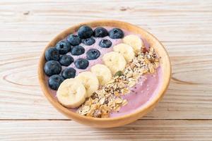 bol de yaourt ou de smoothie avec myrtille, banane et granola - style alimentaire sain photo