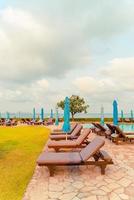 chaise piscine ou lit piscine et parasol autour de la piscine avec fond de plage de mer à pattaya en thaïlande photo