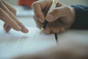 fermer asiatique Masculin gens voiture vendeur ou Ventes directeur des offres à vendre une voiture et explique et lit le termes de signature une voiture Contrat et assurance. photo