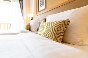 décoration d'oreillers confortables sur le lit dans la chambre d'hôtel photo