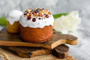 gâteaux de fête avec glaçage blanc, noix et raisins secs avec œufs de pâques sur la table de fête photo