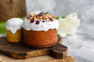 gâteaux de fête avec glaçage blanc, noix et raisins secs avec œufs de pâques sur la table de fête photo