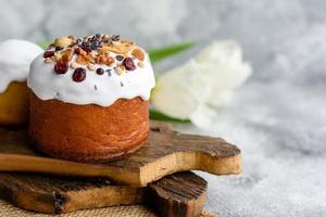 gâteaux de fête avec glaçage blanc, noix et raisins secs avec œufs de pâques sur la table de fête photo