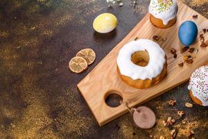 gâteaux de fête avec glaçage blanc, noix et raisins secs avec œufs de pâques sur la table de fête photo