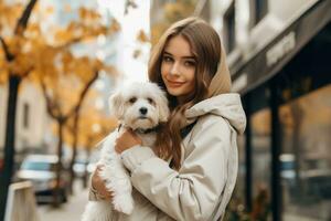 fille dans une blanc veste en marchant vers le bas le rue avec une chien dans sa bras photo