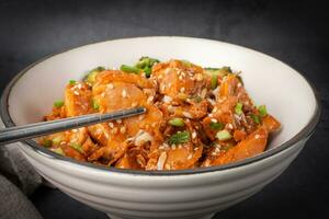 baguettes avec délicieux sucré couper poulet riz, sésame graines, tranché printemps oignons, brocoli, et des légumes. asiatique nourriture, Japonais aliments. proche en haut photo