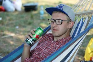 kharkov, ukraine - 31 juillet 2021 homme avec boîte de conserve verte de bière heineken lager produite par la société de brassage néerlandais heineken nv photo