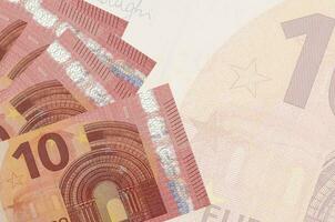 10 billets en euros sont empilés sur fond de gros billets semi-transparents. arrière-plan abstrait des affaires photo