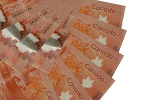 Des billets de 50 dollars canadiens se trouvent isolés sur fond blanc avec un espace de copie empilé en forme d'éventail de près photo
