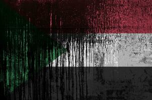 Soudan drapeau représenté dans peindre couleurs sur vieux et sale pétrole baril mur fermer. texturé bannière sur rugueux Contexte photo