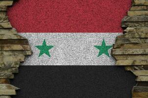 drapeau de la syrie représenté dans des couleurs de peinture sur un vieux mur de pierre agrandi. bannière texturée sur fond de paroi rocheuse photo
