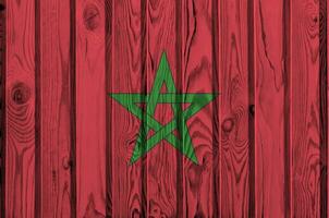 drapeau marocain représenté dans des couleurs de peinture vives sur un vieux mur en bois. bannière texturée sur fond rugueux photo
