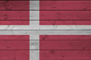 Danemark drapeau représenté dans brillant peindre couleurs sur vieux en bois mur. texturé bannière sur rugueux Contexte photo