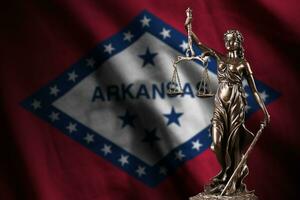 Arkansas nous Etat drapeau avec statue de Dame Justice et judiciaire Balance dans foncé chambre. concept de jugement et Châtiment photo
