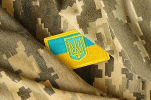 tissu de camouflage militaire avec le drapeau ukrainien sur un chevron d'uniforme photo