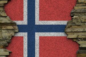 Norvège drapeau représenté dans peindre couleurs sur vieux pierre mur fermer. texturé bannière sur Roche mur Contexte photo