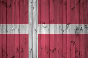 Danemark drapeau représenté dans brillant peindre couleurs sur vieux en bois mur. texturé bannière sur rugueux Contexte photo
